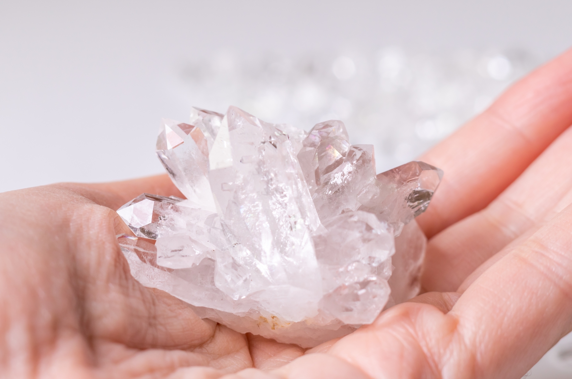 透明な水晶クラスターと日差しが差し込む部屋の写真（天然石の浄化イメージ）