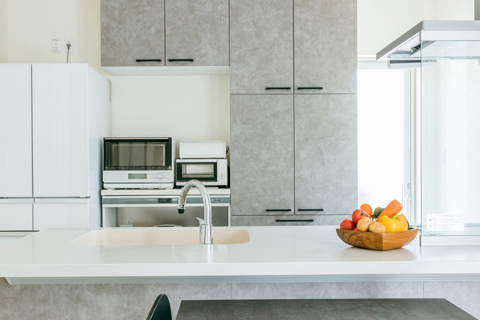 明るく清潔なキッチンと整えられた冷蔵庫の写真（金運を上げる風水配置のイメージ）