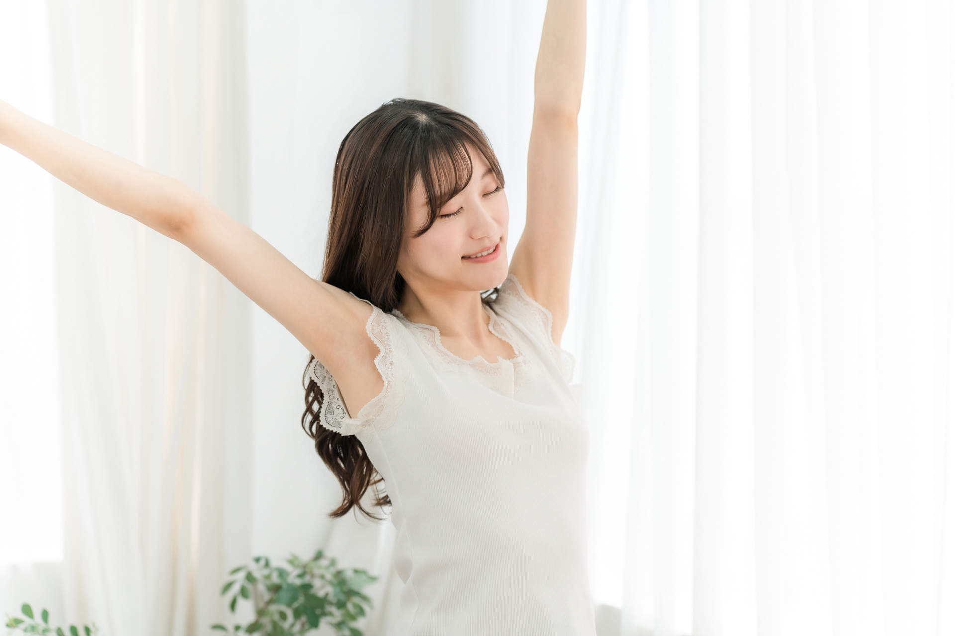 朝日を浴びながら深呼吸する女性の写真(運を呼び込む朝の習慣イメージ)