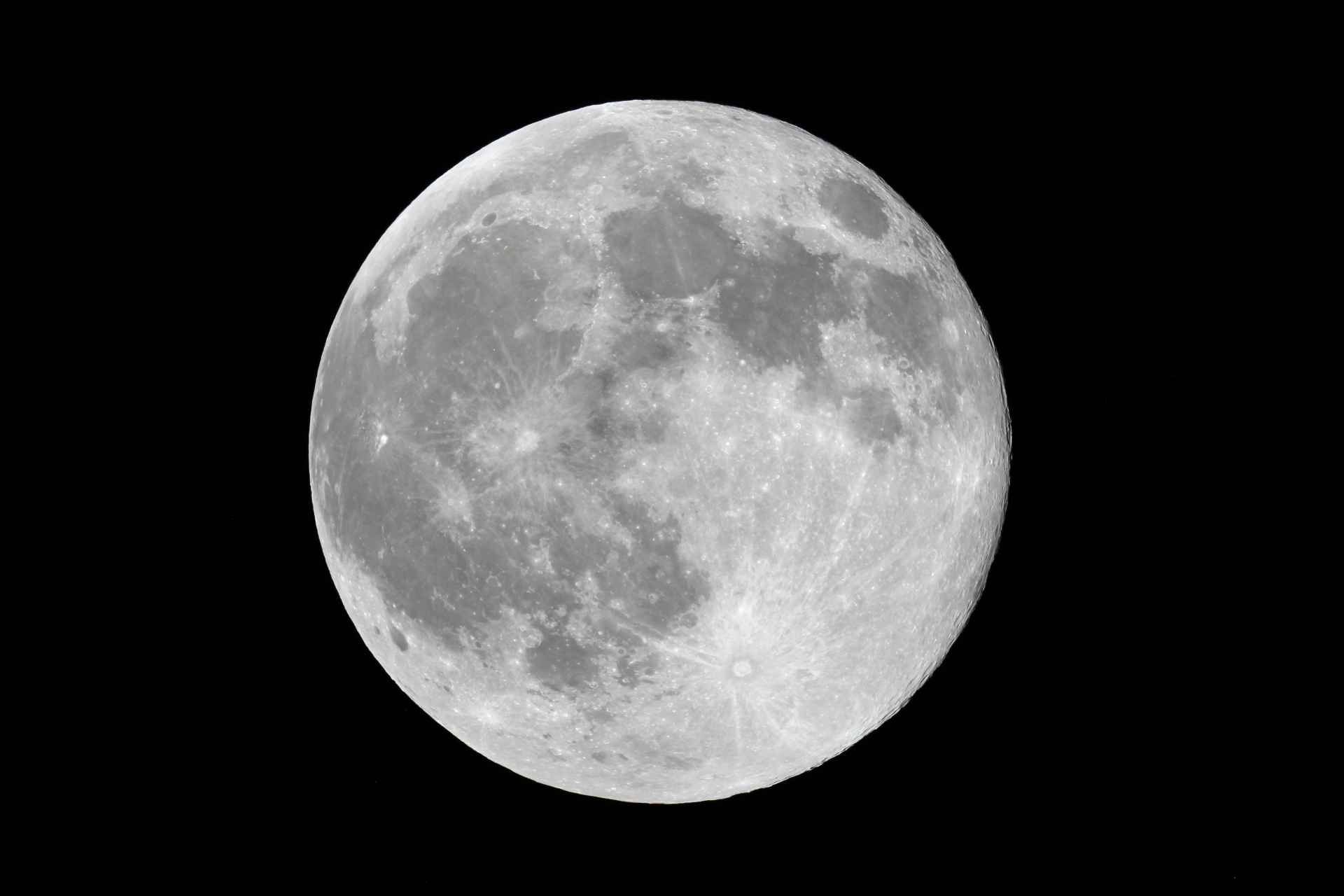 満月の光に照らされた窓辺に天然石とキャンドルが並ぶ写真（満月浄化のイメージ）