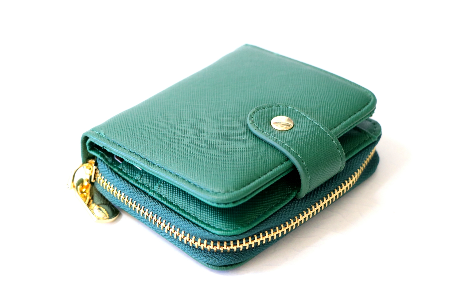 緑色のコンパクトな財布が白い背景の上に置かれている写真