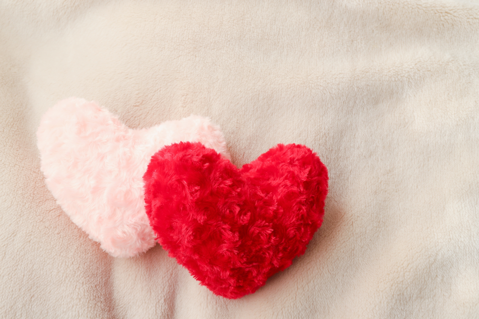 赤と淡いピンクのハートが並ぶ、やさしく寄り添う恋愛イメージ