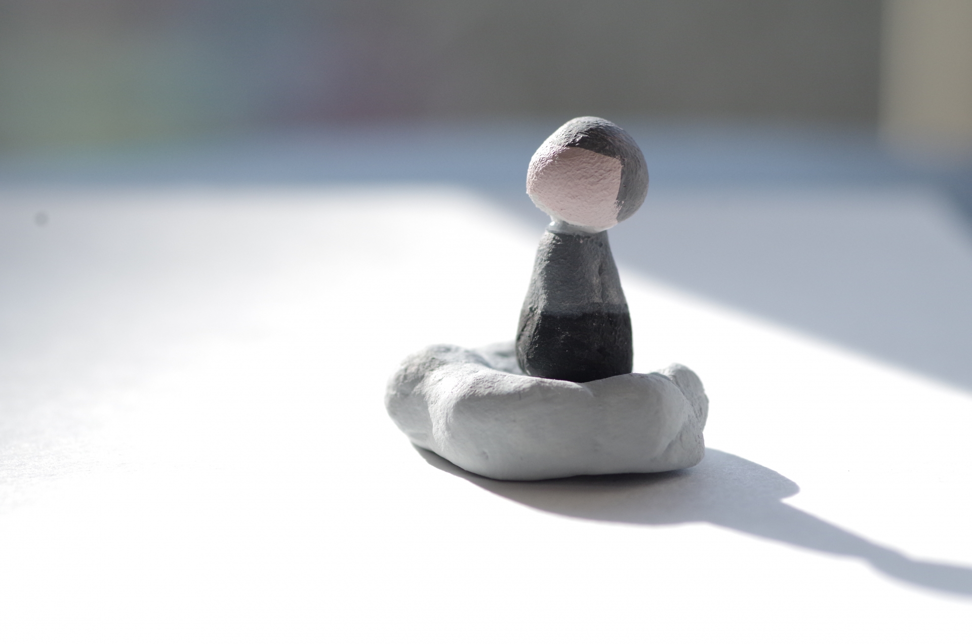 柔らかな光に包まれて座る小さな人形。大切な人を想う優しい時間を表すイメージ