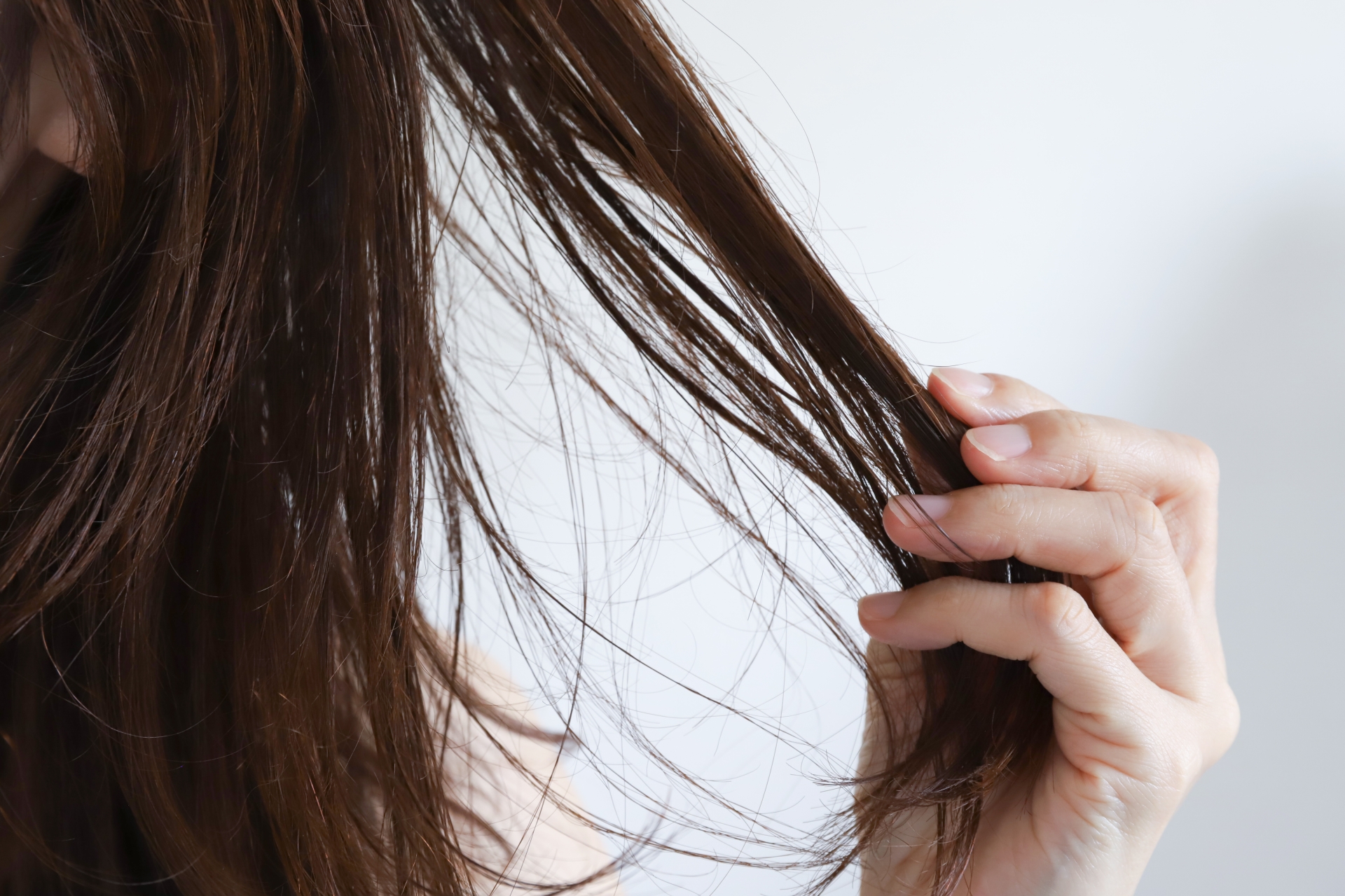 髪に手を触れる女性の手元。気持ちの変化や心の整理をイメージした写真