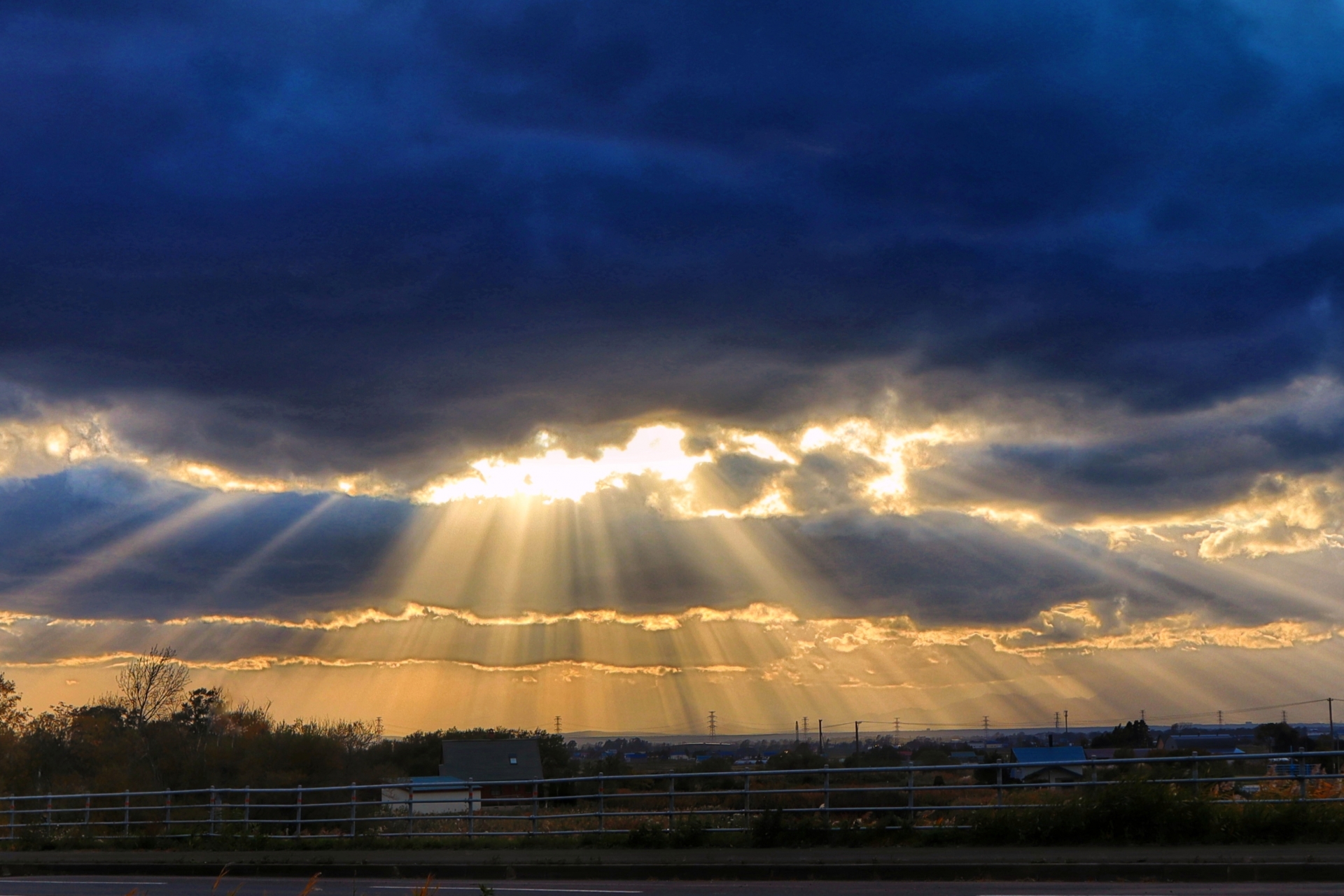 雲間から光が差し込む空の写真。困難の中に希望が見える象徴的な風景